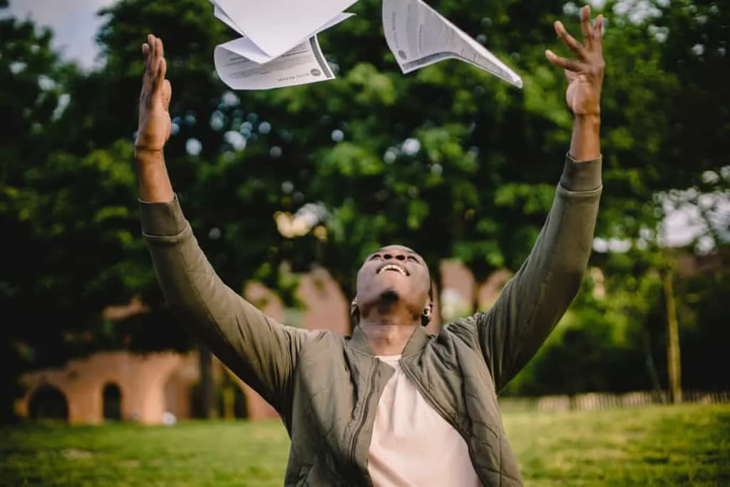 Man throwing papers in the air happily