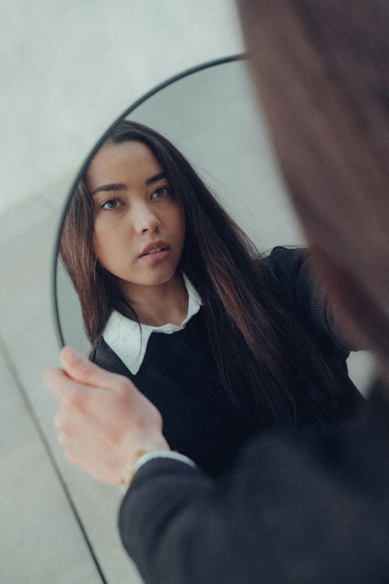 increase self-awareness for perfectionists. Girl looking at a mirror