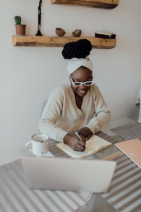 journal prompts for goal-setting. Featured image of woman writing in a journal