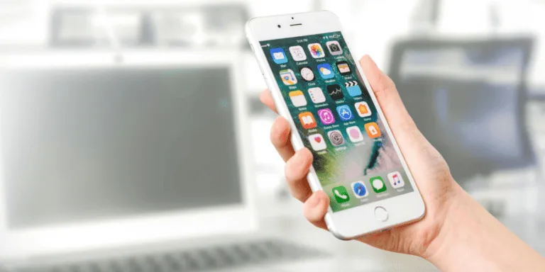 Person Holding Silver Iphone 7 with various social media icons on the screen to symbolise a 6 month social media detox