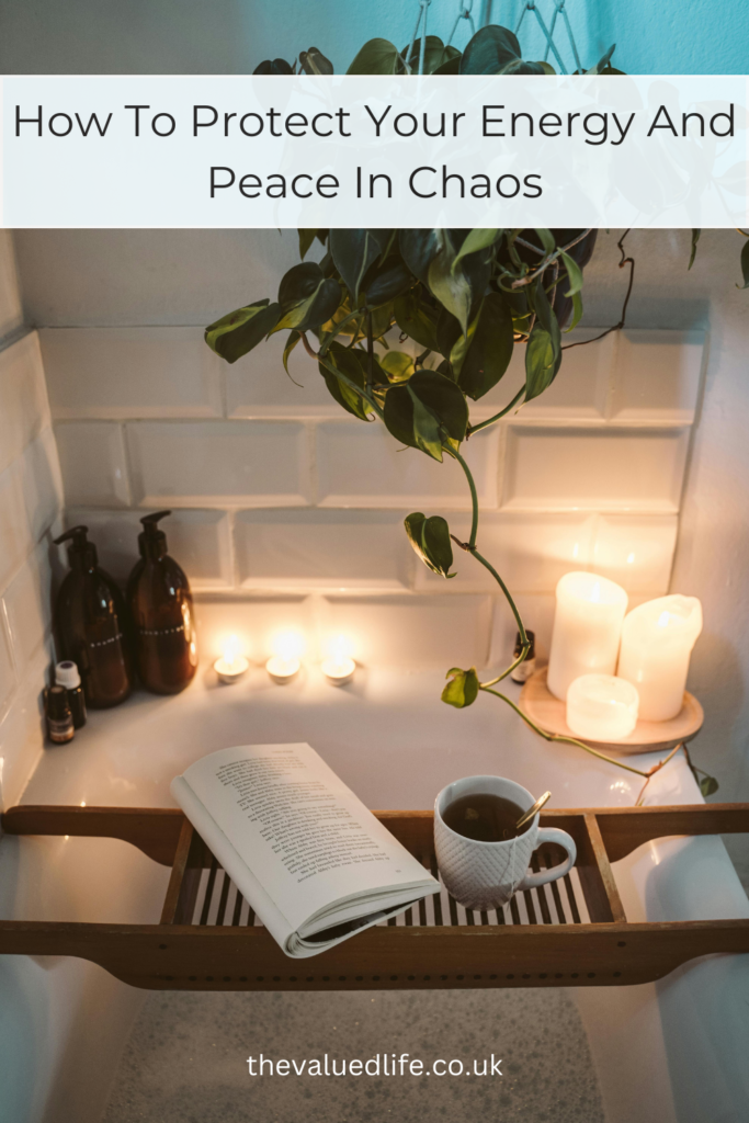 A relaxing setting in the bathroom: lit candles, bath bottles, and a plant to protect peace and energy