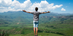 Man Wearing Grey Shirt Standing on Elevated Surface - areas in life to set goals