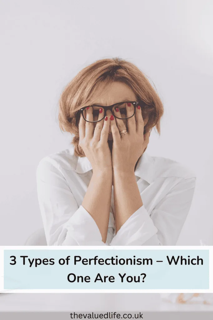 Woman in White Long Sleeve Shirt Wearing Eyeglasses Sitting at a Table with her head in her hands appearing stressed analysing the 3 types of perfectionism