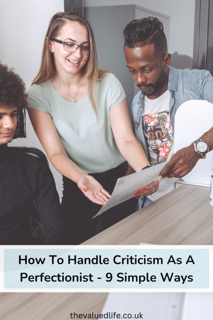 Woman in Green Tank Top pointing out something on a sheet of paper to two men to show how to handle criticism as a perfectionist