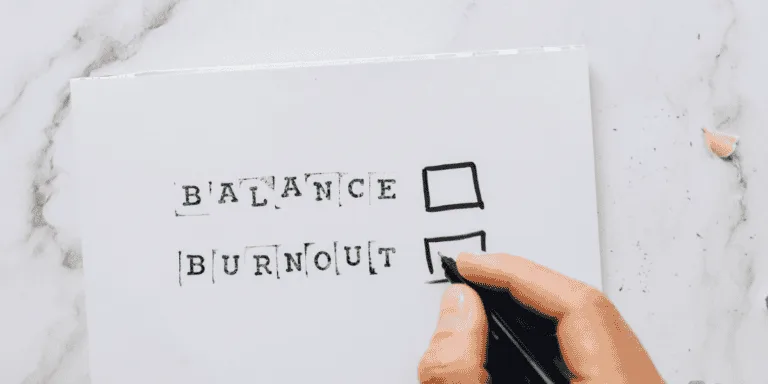 Close-up Photo of Checklist on White Paper. Items say balance and burnout to symbolise perfectionism vs high standards