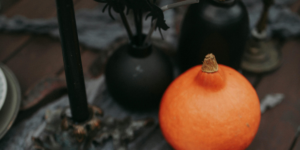 Pumpkin next to a open book with a spooky image for october journal prompts