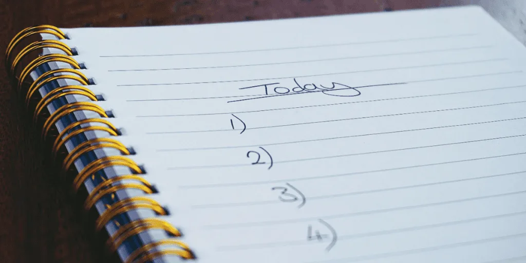 A spiral notebook open to a blank to-do list titled 'Today,' suggesting the concept of a 'bare minimum to-do list' to help overcome procrastination by setting achievable daily goals.