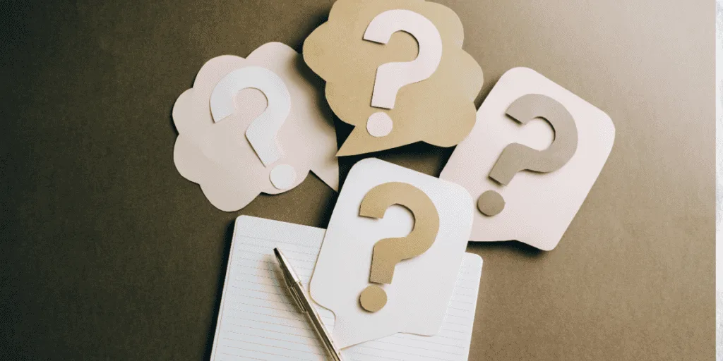 Colorful question mark cutouts placed on a notebook, symbolizing the uncertainty and self-doubt often tied to perfectionism