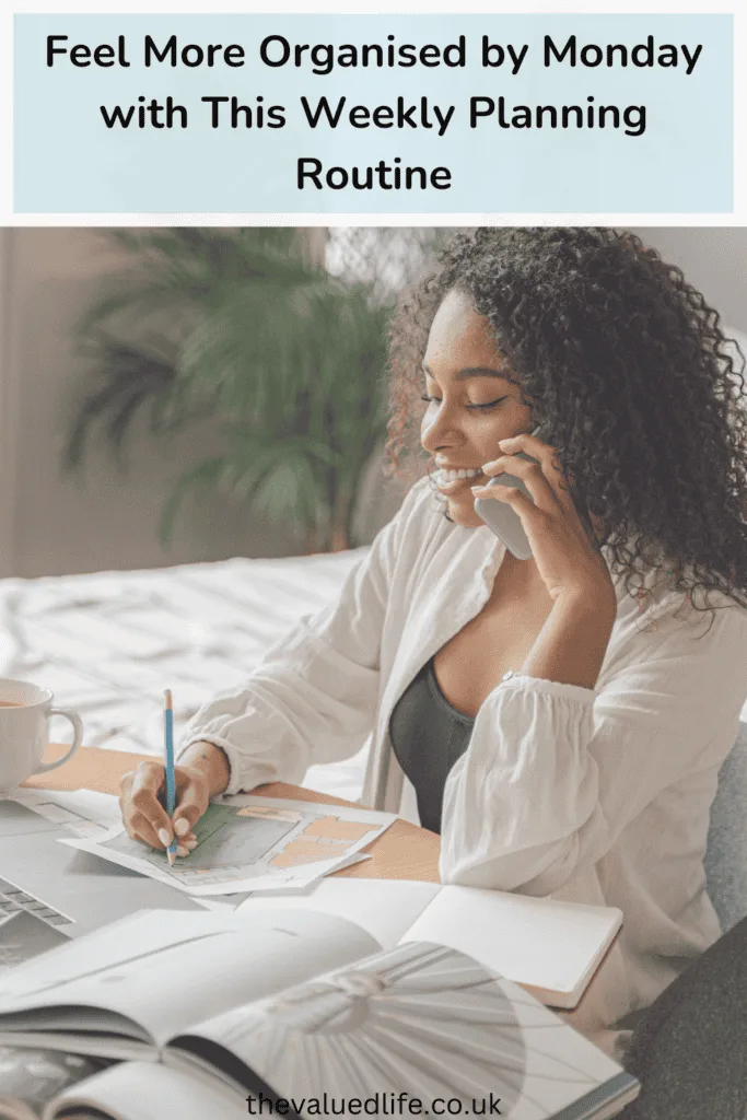 A woman sitting at a desk, planning her week with a notebook, colored markers, and a laptop, while speaking on the phone. This relaxed setting showcases a productive weekly planning routine designed to improve organization and efficiency.
